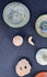 Blue-green Roman glass vessel lid with raised knob and mineral encrustation