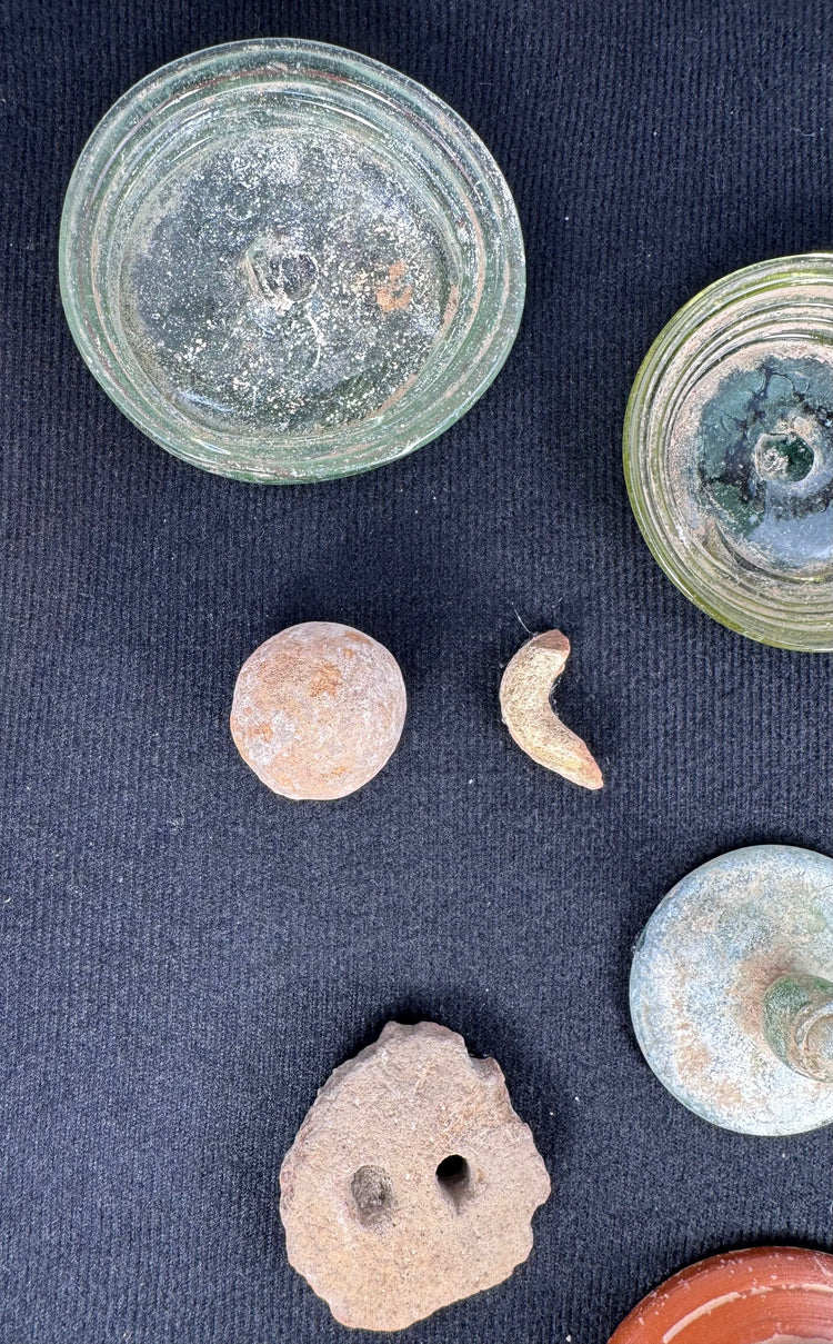 Blue-green Roman glass vessel lid with raised knob and mineral encrustation