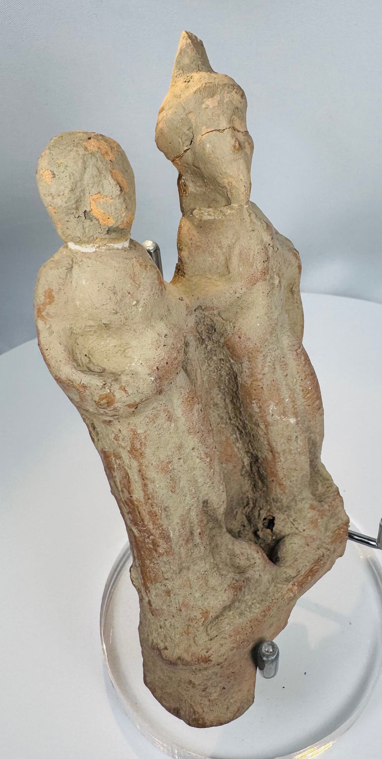 Classical Mediterranean terracotta figural group with one figure wearing a tall conical headdress.