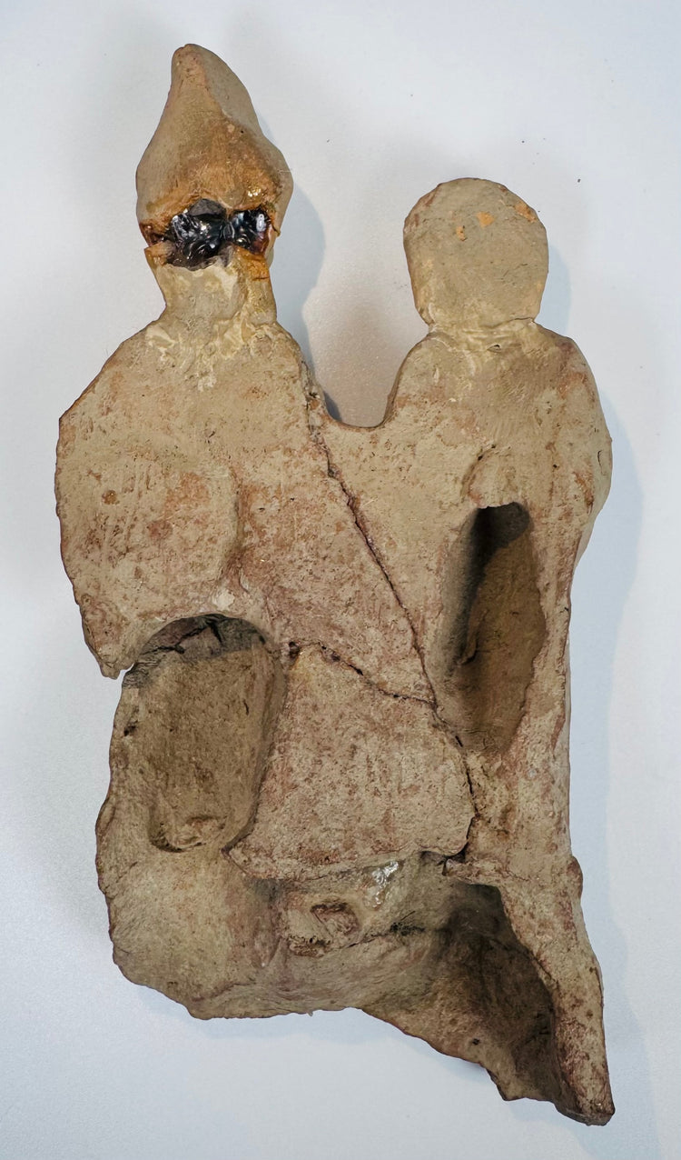 Close-up of an ancient Mediterranean terracotta figural group displaying weathered surfaces and archaeological encrustation.