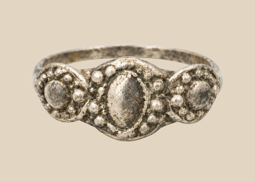 Ancient Late Roman–Byzantine silver ring featuring a clustered bezel of three oval motifs with natural aged patina, circa 300–600 CE.