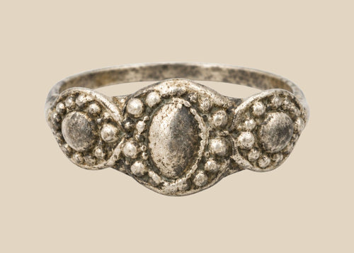 Ancient Late Roman–Byzantine silver ring featuring a clustered bezel of three oval motifs with natural aged patina, circa 300–600 CE.