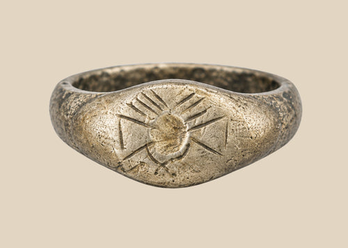 Ancient silver signet ring with finely engraved sunburst motif on bezel, thin rounded band, and natural aged patina, dating to the Late Roman to Early Byzantine period, circa 200–500 CE.