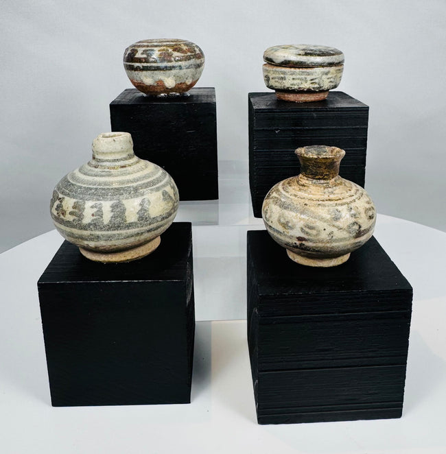 Sukhothai Period Sawankhalok pottery group including covered jars and bottle-shaped vessels with traditional painted decoration.
