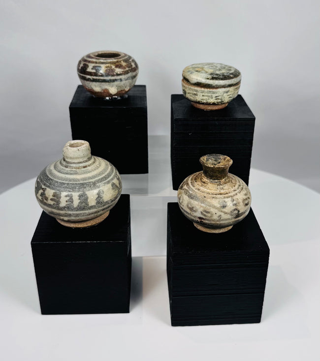 Ancient Thai Sawankhalok ceramic vessels with iron-black painted motifs beneath a transparent glaze, dating to the 14th–15th century CE.