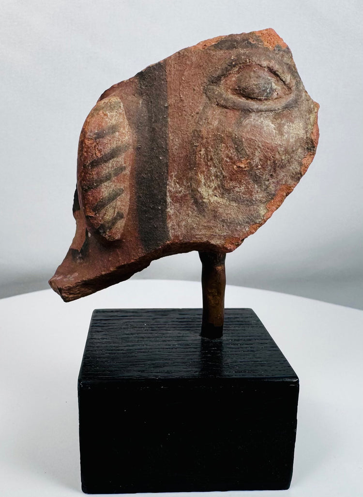Pre-Columbian style terracotta fragment showing painted ear decoration and stylized facial features