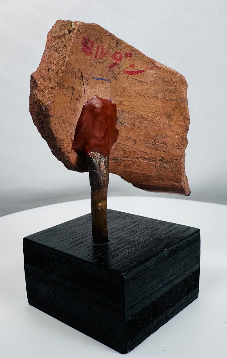 Terracotta sculptural fragment with almond-shaped eye, geometric forms, and traces of original paint