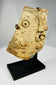 Archaeological terracotta fragment of a Greco-Roman theatrical mask mounted on modern display stand.