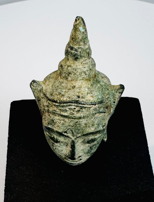 Early Southeast Asian Buddhist devotional sculpture with serene Buddha face and aged green bronze surface