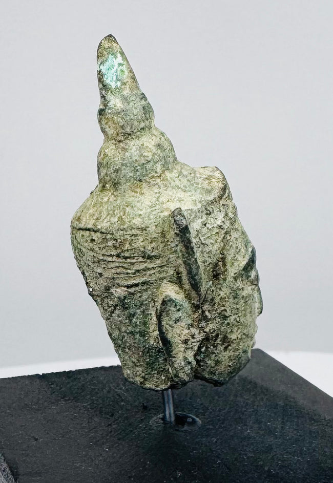 Small bronze Buddha head artifact from Southeast Asia with traditional Buddhist iconography and natural patina