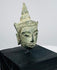 Antique Southeast Asian Buddha head with pointed topknot, tranquil expression, and weathered bronze patina