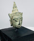 Antique Southeast Asian Buddha head with pointed topknot, tranquil expression, and weathered bronze patina