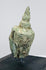 Historic bronze Buddha head with peaceful facial features, elongated ears, and centuries-old verdigris patina