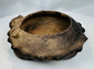 Side profile of an ancient West Mexican tripod vessel highlighting the sculpted zoomorphic heads and hollow leg construction.