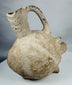 Ancient Yortan pig-shaped pottery vessel with projecting snout, tripod feet, and stirrup handle.