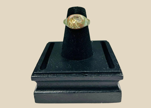 Ancient bronze ring with a finely engraved elephant motif on the bezel, green patina from age, symbolizing wisdom, power, and protection, circa 1st Millennium BCE.