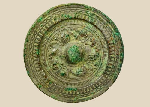Han Dynasty bronze mirror, circa 206 BCE–220 CE, with engraved geometric and mythical motifs, central suspension knob, and rich green patina.