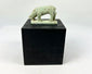 Ancient Egyptian faience shrew amulet, Late Period to Ptolemaic, pale green glaze with burial encrustations, mounted on display stand.