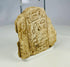 Side view of carved limestone fragment from ancient Egypt with preserved hieroglyphs.