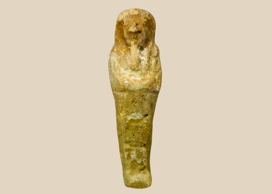 Ancient Egyptian limestone ushabti figurine displayed on a white museum stand