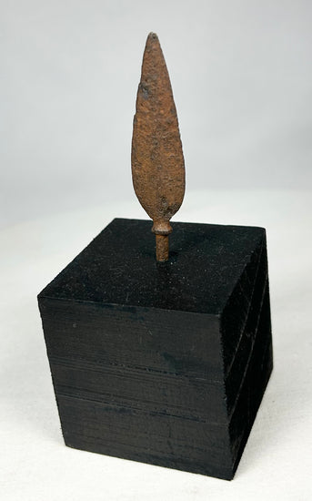 Ancient European iron arrowhead relic mounted on black display base, front view