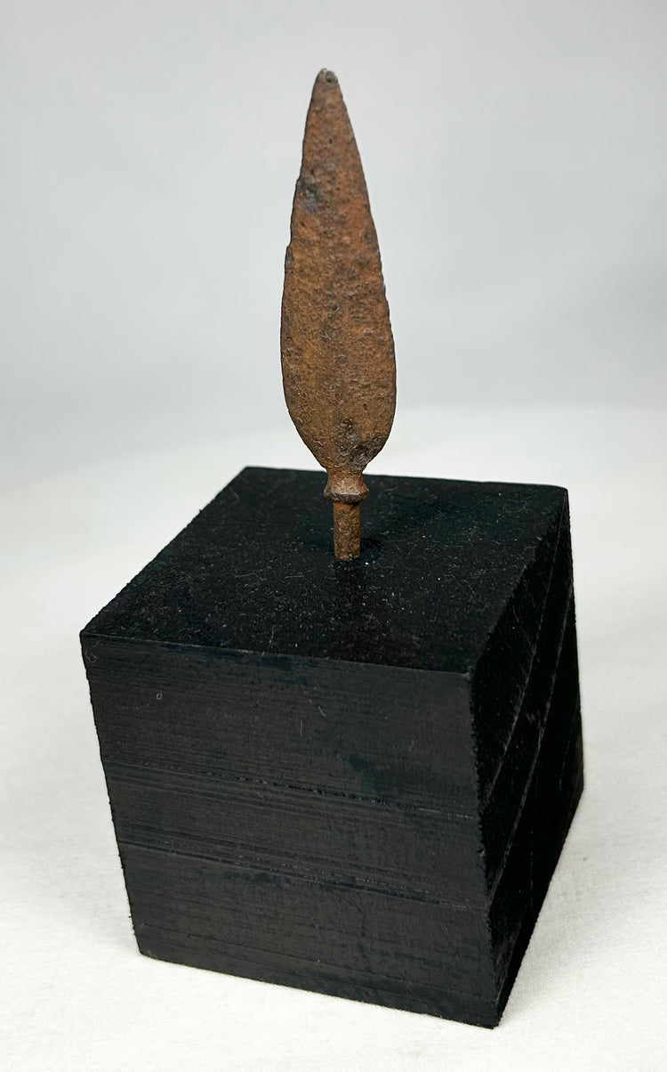 Ancient European iron arrowhead relic mounted on black display base, front view