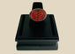 Oval carnelian intaglio ring from the Ancient Near East, 1st millennium BCE. Features engraved animal and symbolic motifs on red carnelian, set in a silver bezel, displayed on a black stand. Excellent condition with finely detailed intaglio carvings.