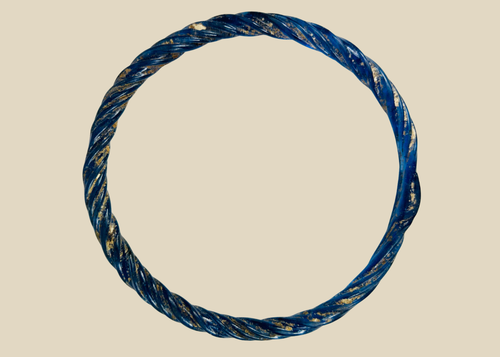 Ancient Roman glass bracelet with cobalt-blue hue, twisted design, and iridescent patina from antiquity.