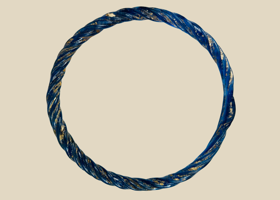 Ancient Roman glass bracelet with cobalt-blue hue, twisted design, and iridescent patina from antiquity.