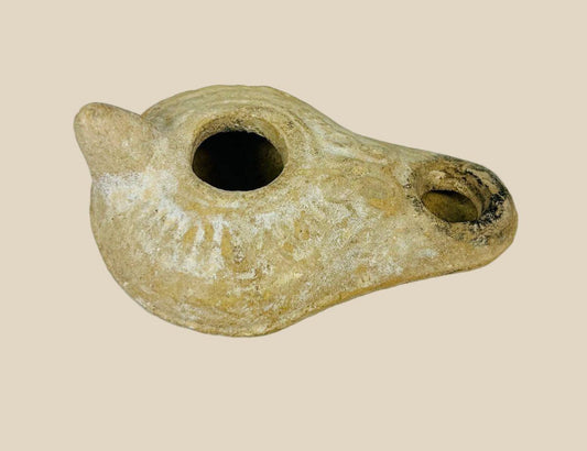 Roman terracotta oil lamp, 1st–3rd century CE, with nozzle, filling hole, and soot marks from ancient use, reflecting daily and ritual life.