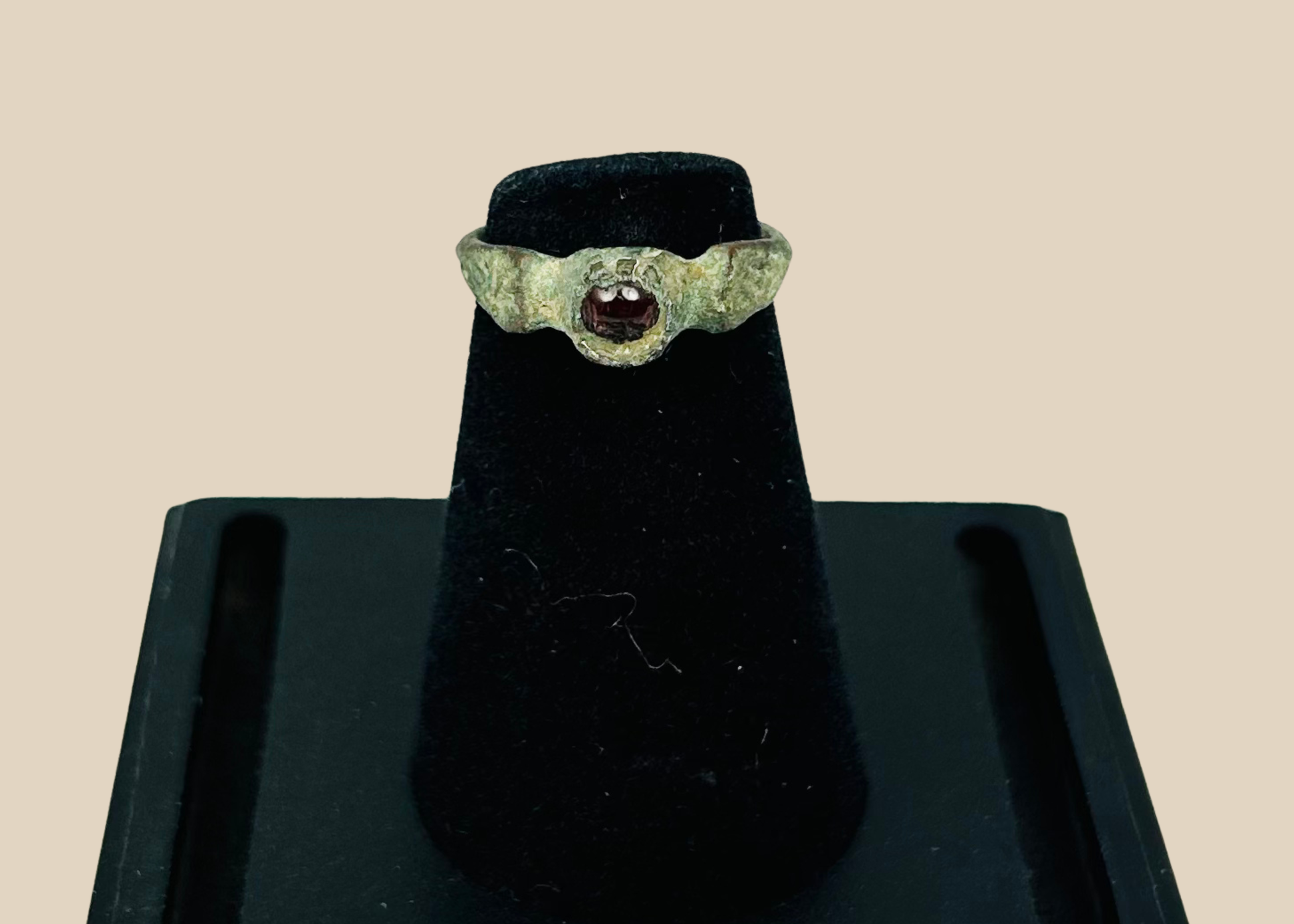 Ancient Roman bronze ring with inset deep red garnet gemstone mounted for display