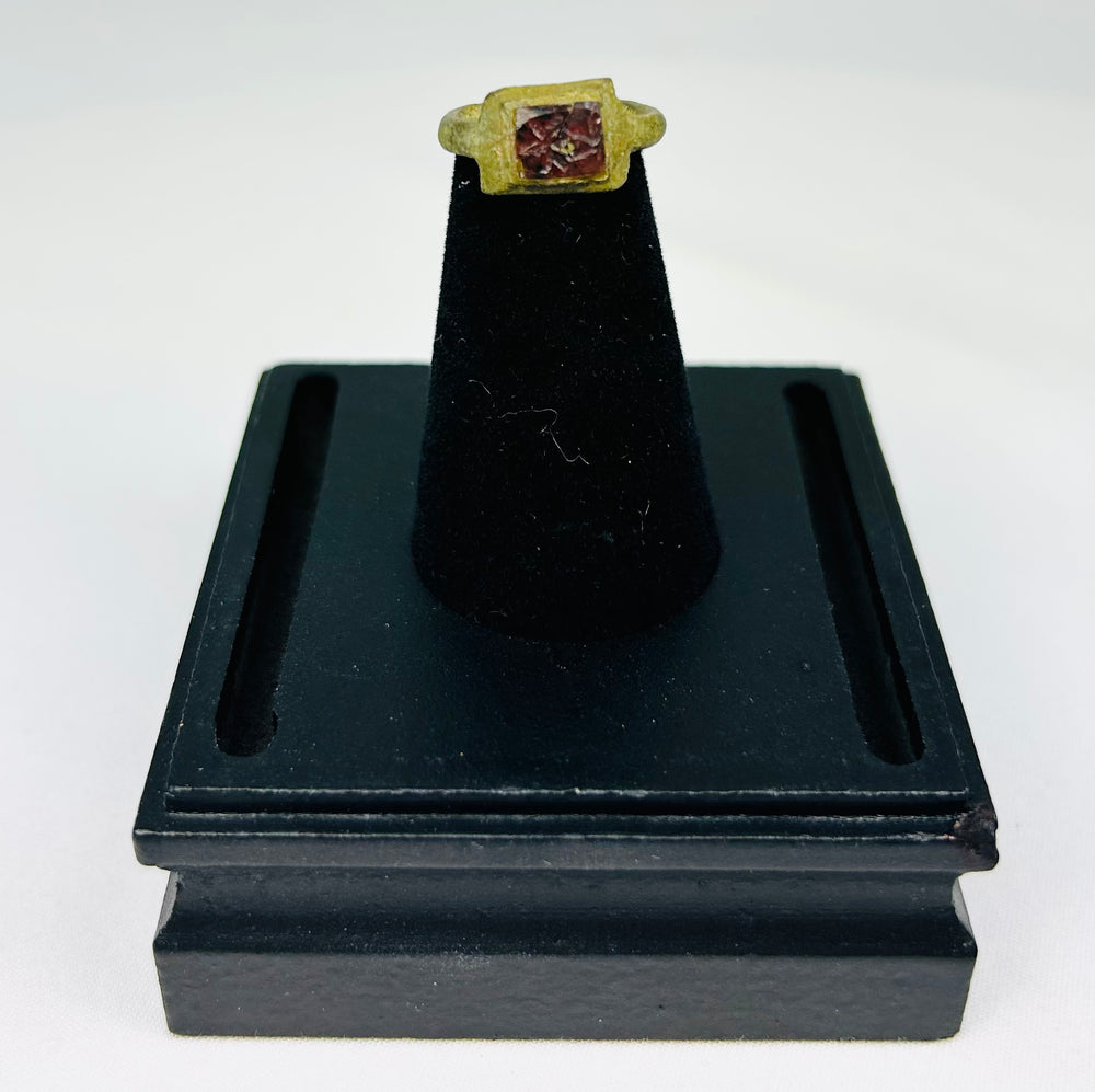 Ancient Roman bronze ring with inset red glass intaglio mounted for display