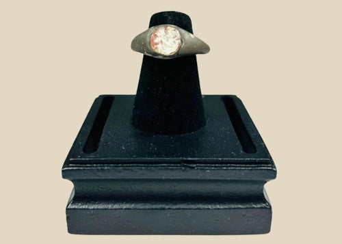 Ancient silver ring from the Mediterranean or Near East, 1st Millennium BCE, featuring a polished carnelian intaglio with traces of engraved motif. Smooth silver band with natural patina highlights the gemstone, reflecting its use as both a personal adornment and protective talisman in antiquity.