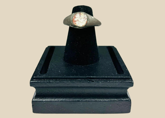 Ancient silver ring from the Mediterranean or Near East, 1st Millennium BCE, featuring a polished carnelian intaglio with traces of engraved motif. Smooth silver band with natural patina highlights the gemstone, reflecting its use as both a personal adornment and protective talisman in antiquity.