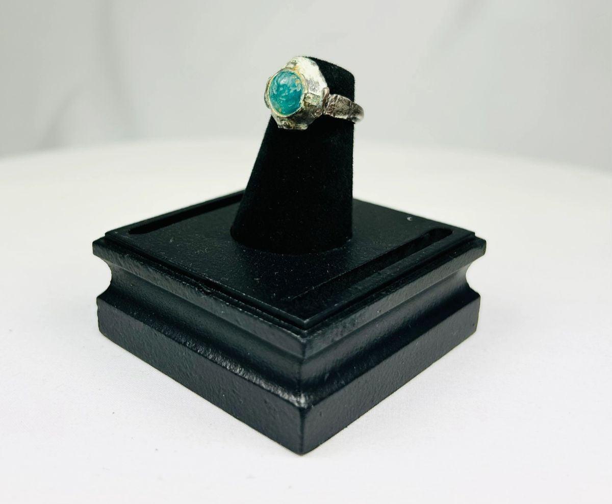 Ancient silver ring from the Near East or Mediterranean, 1st millennium BCE, featuring an engraved prancing horse with mounted rider and a raised turquoise bezel. Silver band with natural patina highlights fine ancient metalworking, symbolizing nobility, strength, and protective talismanic power.