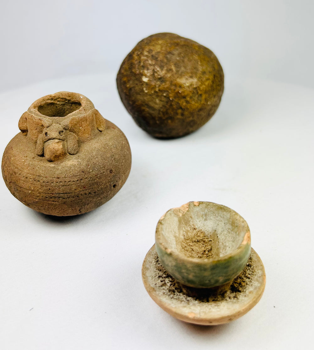 Ancient spherical stone object from South or Southeast Asia, dense polished surface with natural patina, possibly grinding or projectile tool.