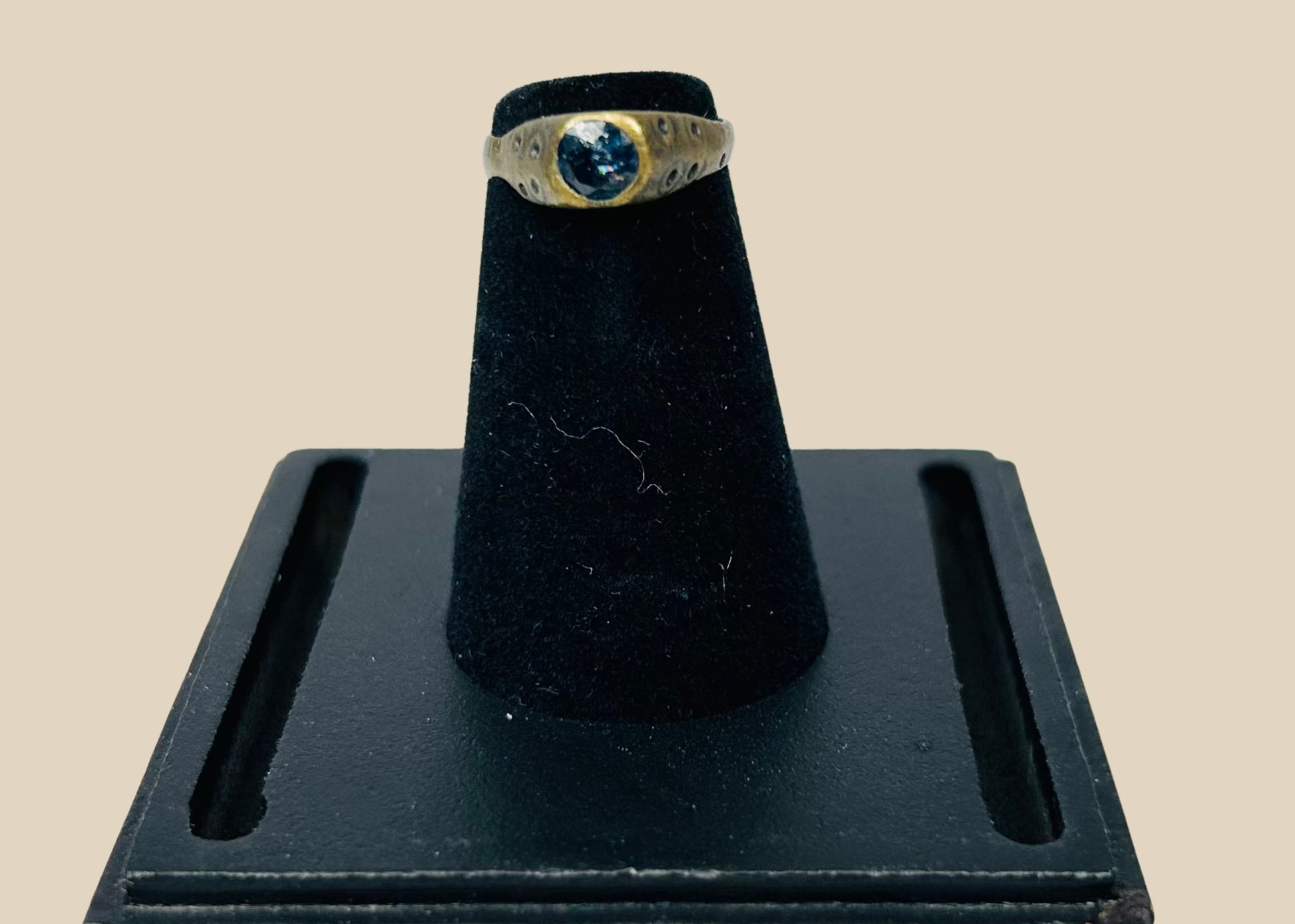 Ancient brass ring with oval engraved bezel on a display stand