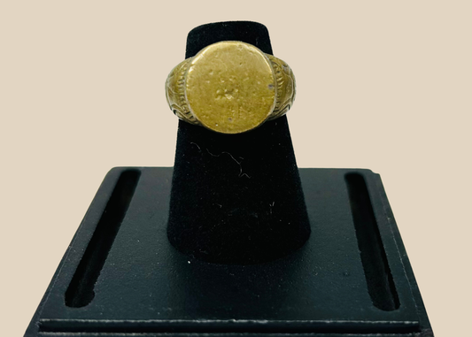 Ancient bronze ring with geometric scrollwork on a clear display stand