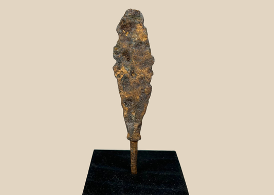 Ancient iron arrowhead relic mounted on black display base, front view.
