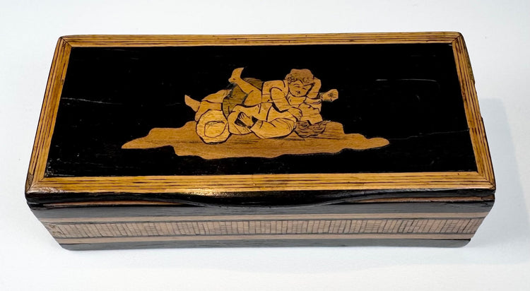 Top view of Anglo-Indian marquetry box showing reclining figural wood inlay and decorative borders