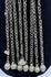 Afghan tribal pendant displaying handcrafted silver-toned metalwork, red glass accents, and ceremonial chain tassels.