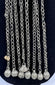 Afghan tribal pendant displaying handcrafted silver-toned metalwork, red glass accents, and ceremonial chain tassels.