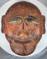 Traditional tribal wooden mask displaying abstract facial forms and authentic aged wear