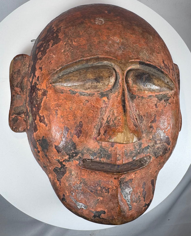 Traditional African wooden ceremonial mask featuring elongated eyes and geometric carving