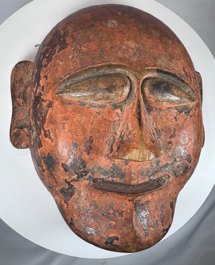 Traditional African wooden ceremonial mask featuring elongated eyes and geometric carving