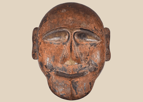 Hand-carved African tribal mask with stylized facial features and aged patina