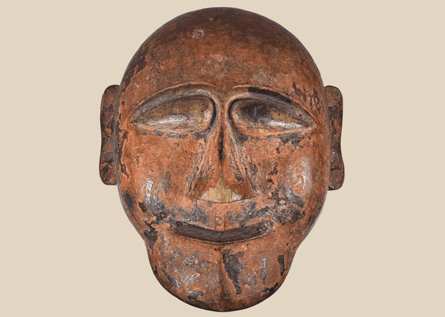 Hand-carved African tribal mask with stylized facial features and aged patina