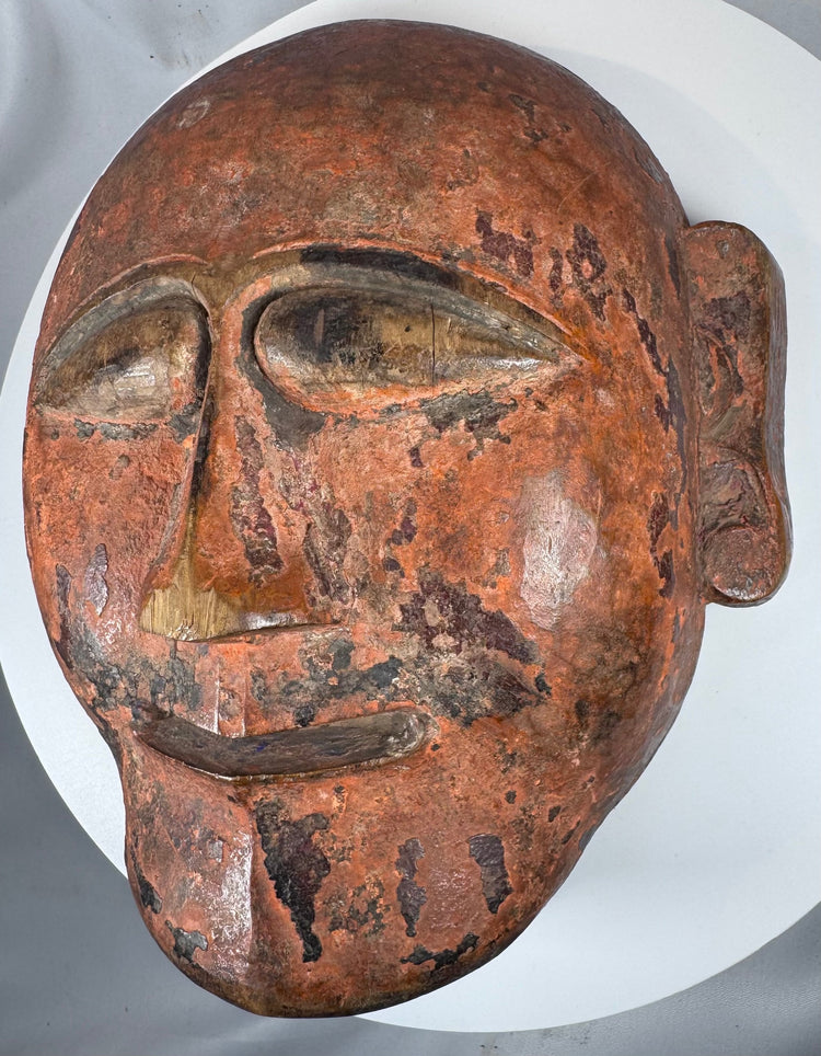 Hand-carved West or Central African wooden mask with projecting mouth and sculptural features