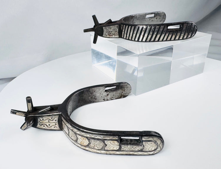 Antique Southwestern horse-riding spurs with engraved foliate silver panels