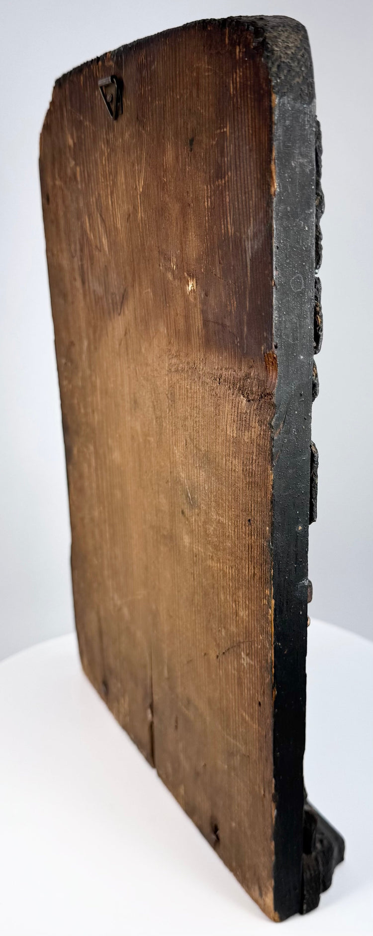 Edge and rear detail of antique carved wood religious relief showing panel thickness, exposed timber and historic wear